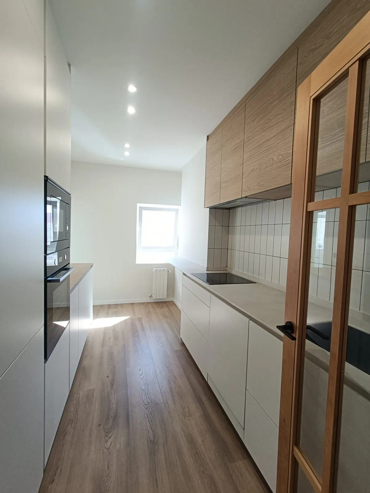 Reforma de cocina alargada en Valladolid con armarios a medida y cocina vitrocerámica